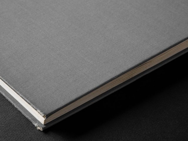 Buku hardcover dengan lembaran halaman putih dan cover hitam