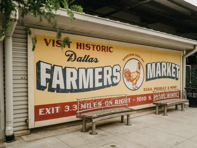 Banner bertuliskan 'Visit Historic Dallas Farmers Market' di depan toko percetakan.