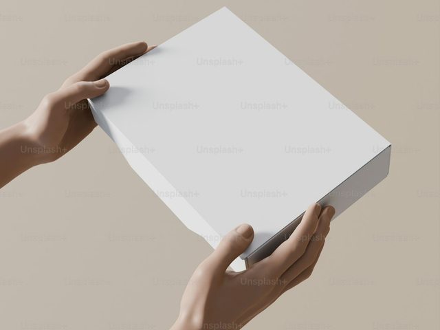 Tangan memegang lembaran kertas putih, siap digunakan untuk berbagai keperluan percetakan.