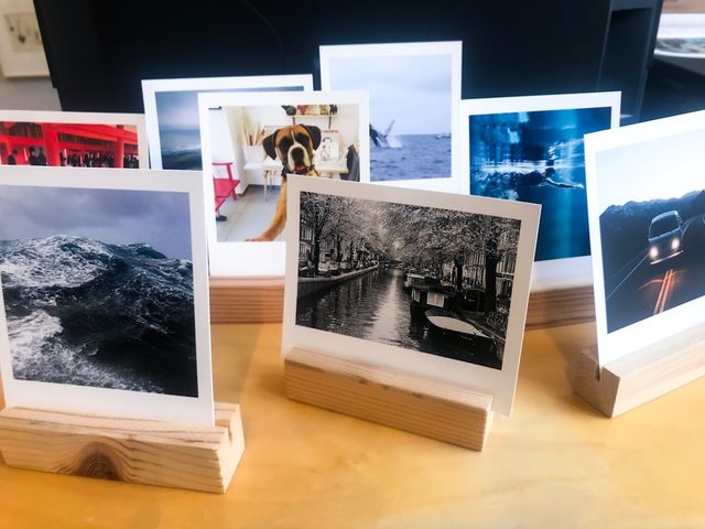 Display of polaroid-style prints on wooden stands, showcasing various scenic images.