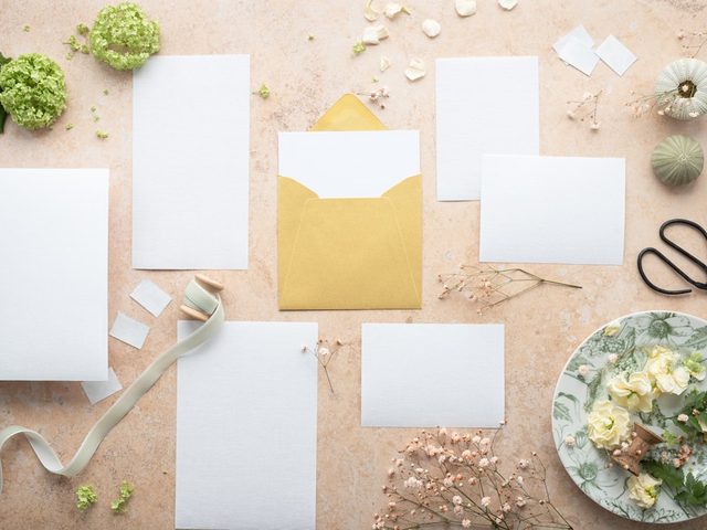 Rangkaian paket percetakan online dengan kertas putih, kuisioner, dan aksesori dekoratif.
